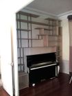 bibliothèque sur mesure, encadrant un piano droit. Plateaux chêne, montant en acier